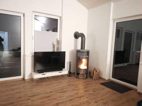 großer TV und Kaminofen mit Sichtfenster