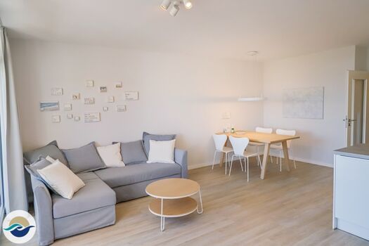 Das großzügige Wohnzimmer verfügt über eine Schlafcouch mit Sessel und einen Essbereich.