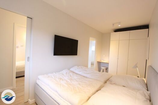 Das Schlafzimmer ist mit einem Boxspringbett (180 x 200 cm), einem Kleiderschrank und einem wandhängenden TV ausgestattet.