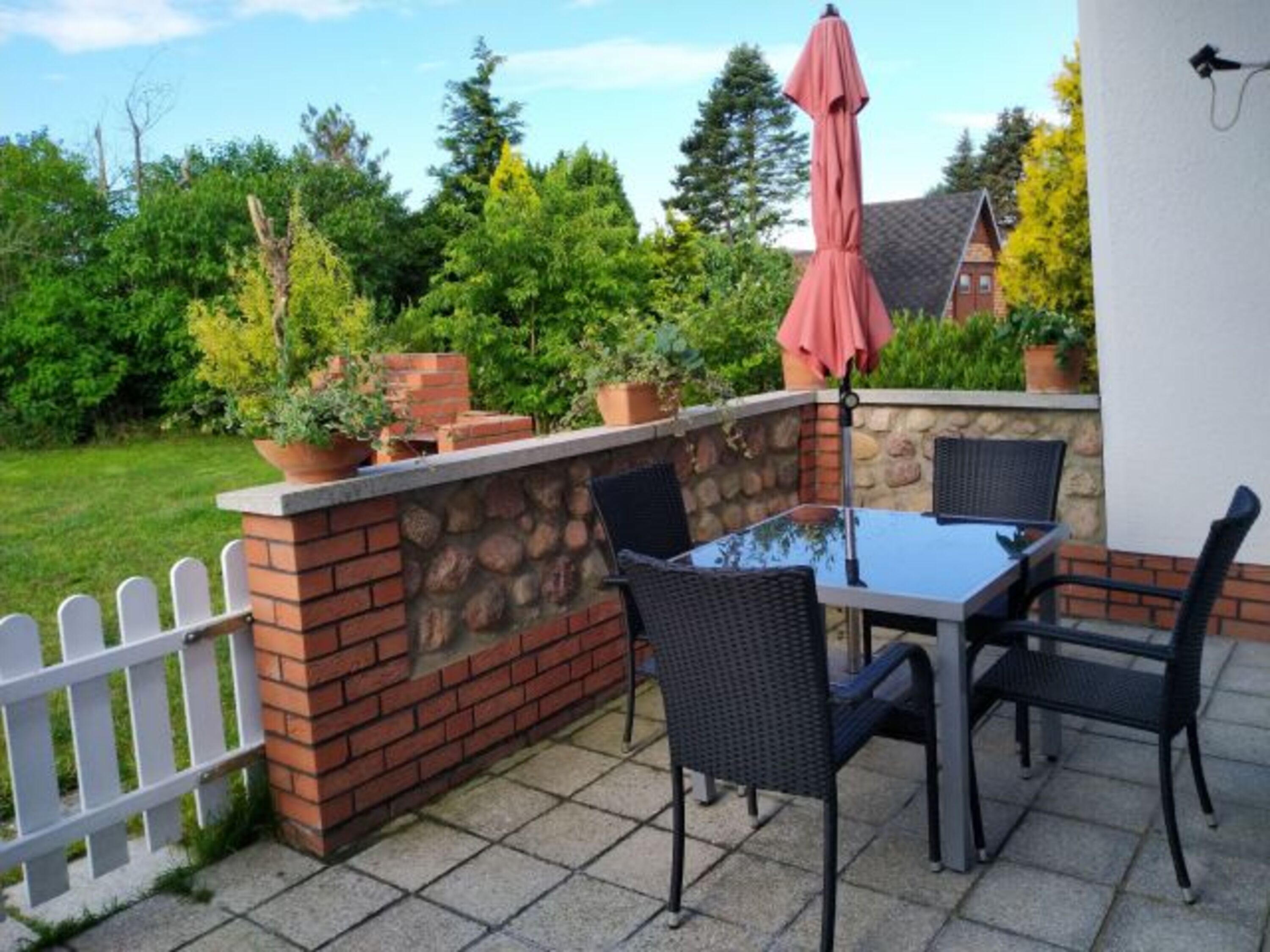 Terrasse mit Tisch, Stühlen und Sonnenliegen