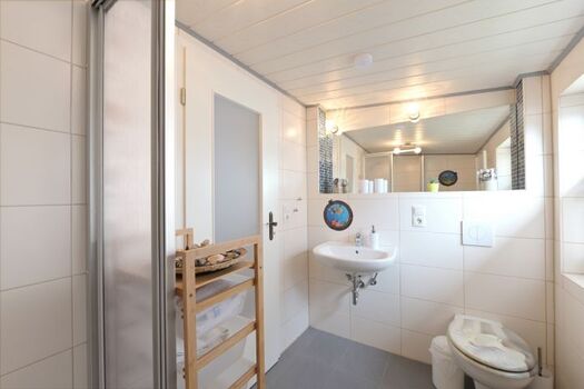 Großes Badfenster mit Pliseegardine ist rechts