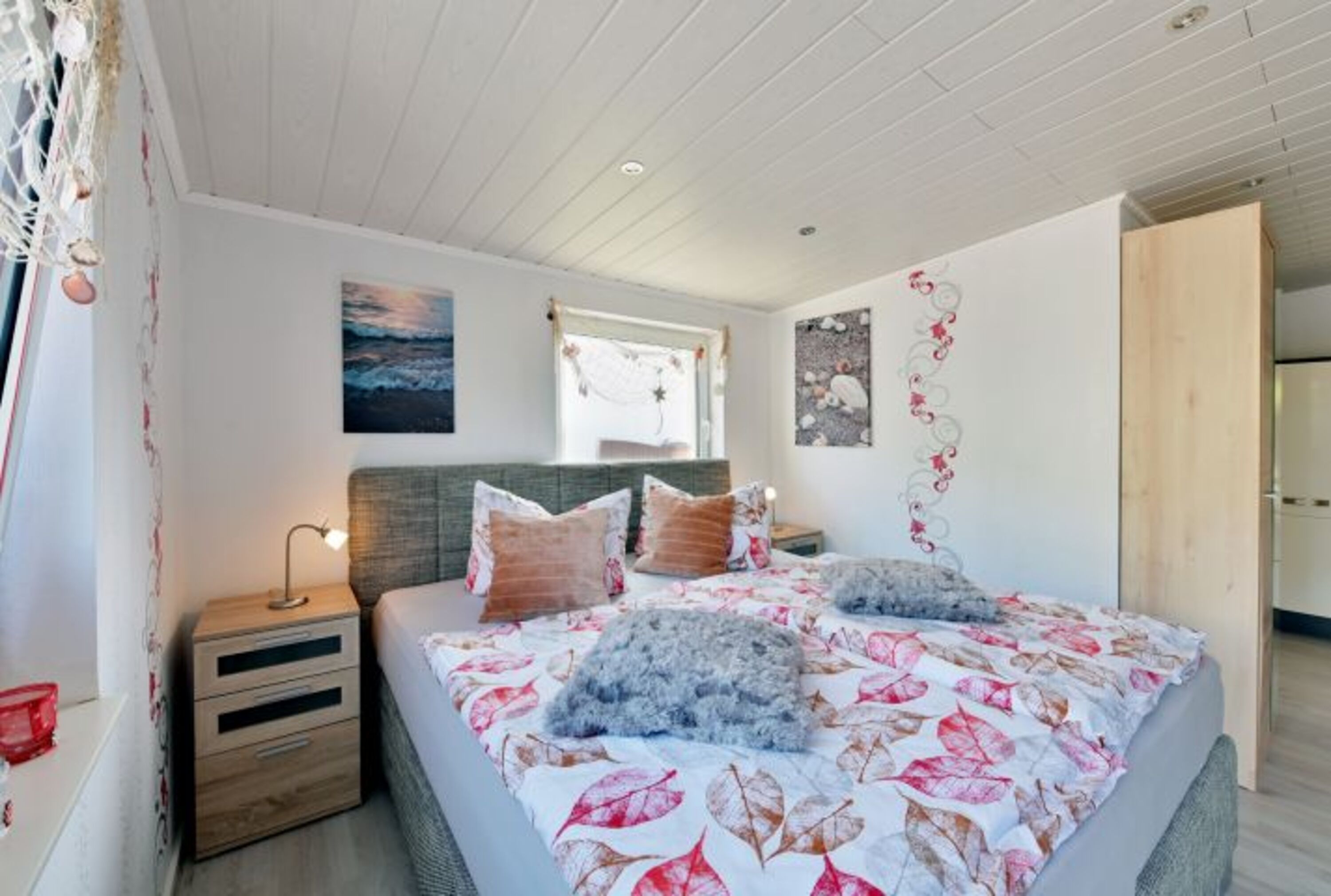 Komfortables Boxspringbett mit 2 kleinen Kommoden und Leselampen