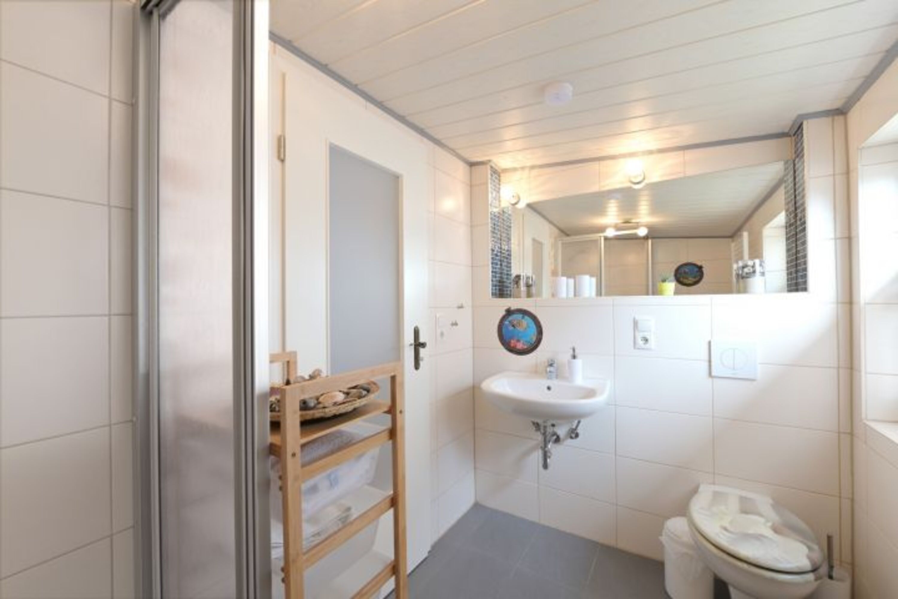 Großes Badfenster mit Pliseegardine ist rechts