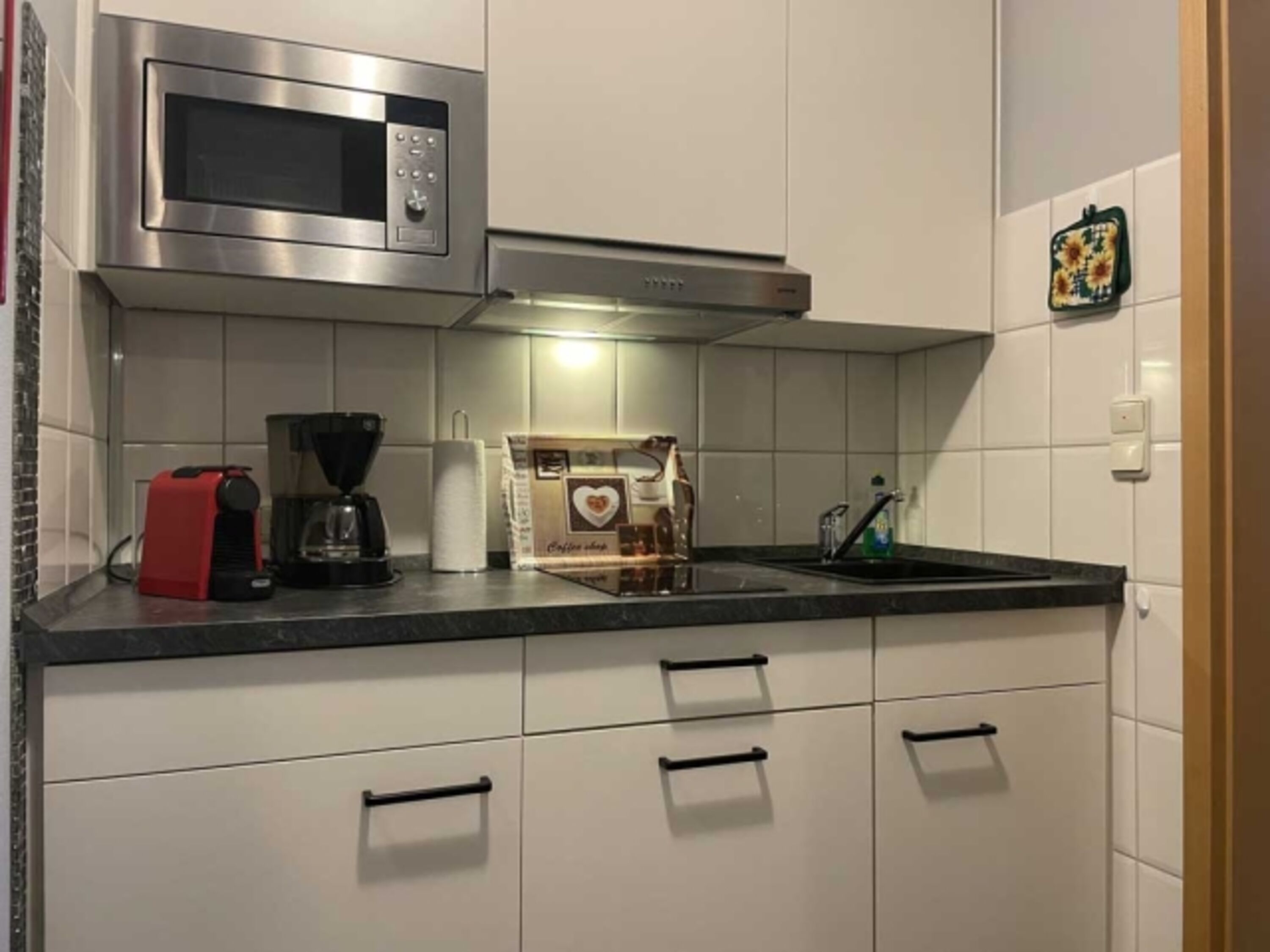 Küche mit Spülmaschine und Mikrowelle mit Grill