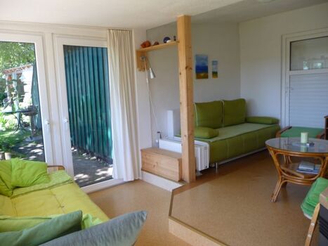 Blick im Wintergarten mit den 2 Schlafsofas zum Aufbetten zu den Westfenstertüren hinaus