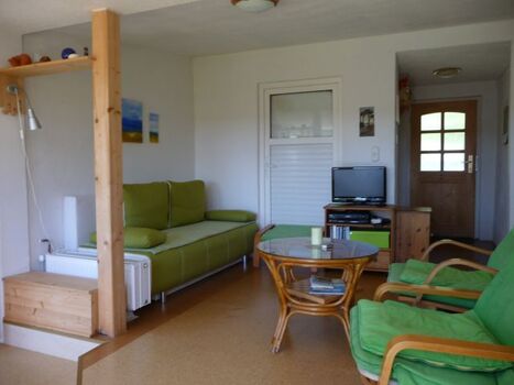 Blick in den Wintergarten auf den Eingangsbereich mit kleinem Flur und Garderobe