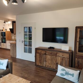 Wohnzimmer mit großem Fernseher und Blu-ray Player, Bücher über Rügen und Reiseführer