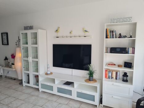 Gemütliches Wohnzimmer mit großem TV und gemütlicher Beleuchtung