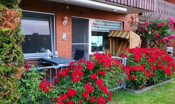 Eingezäunte Terrasse mit gemütlichem Strandkorb für Zwei