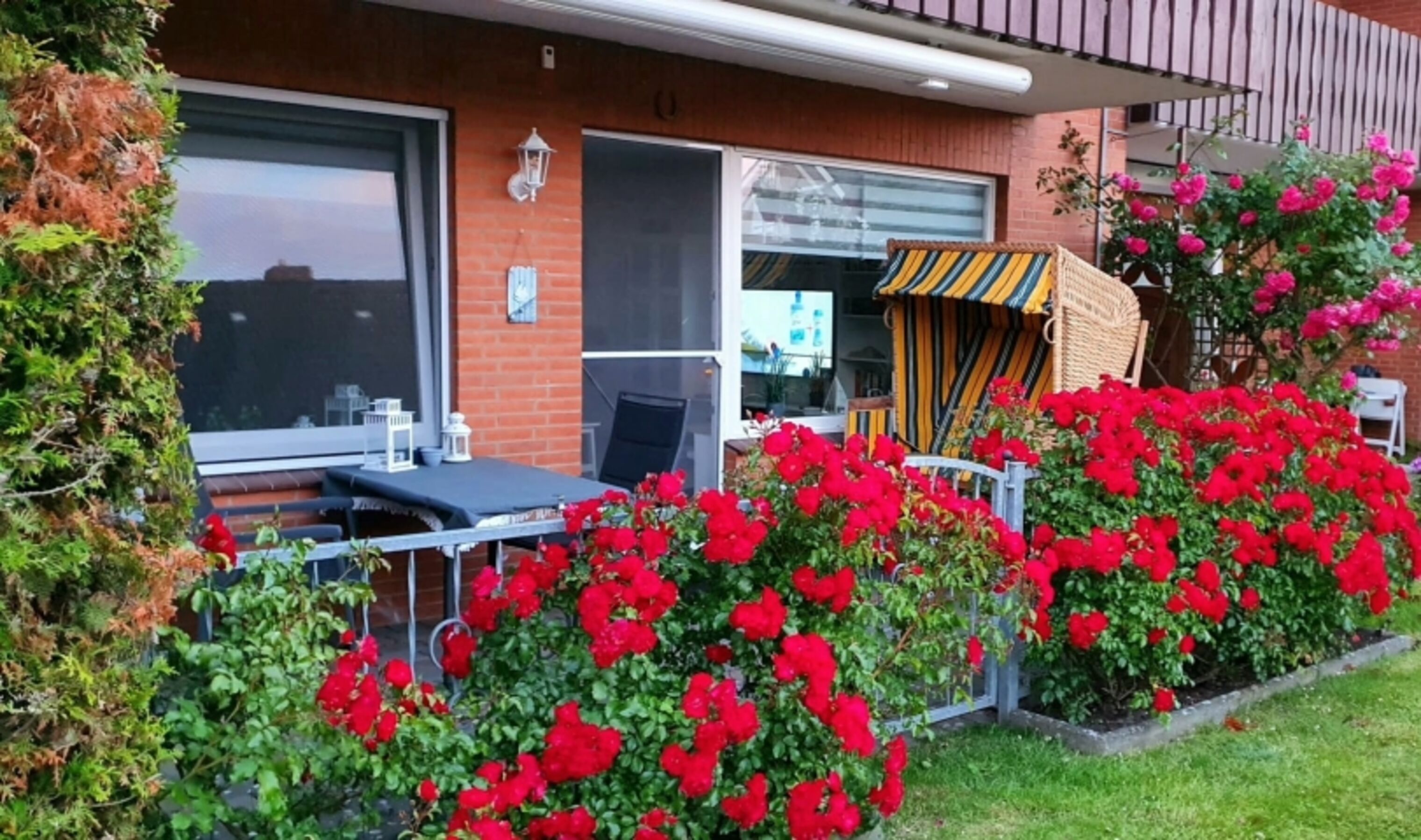 Eingezäunte Terrasse mit gemütlichem Strandkorb für Zwei