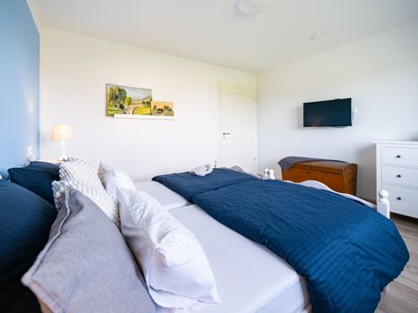Schlafzimmer 1 im EG: Fernseher, Rolladen, Fliegengitter, Kleider-Kommode, Fernseher.