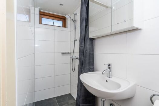 Das neue Badezimmer mit Dusche, Waschbecken, Toilette