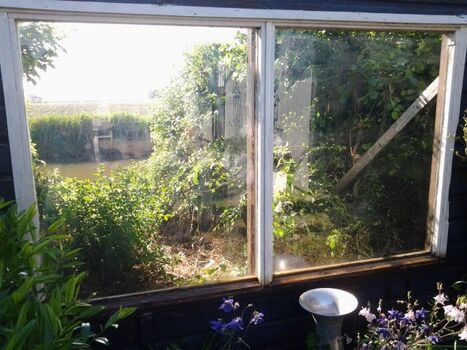 Blick aus dem Garten auf die Gracht und die Polderlandschaft