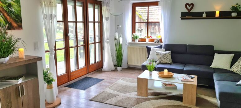 Wohnzimmer mit L-Lounge  Couch // 55 Zoll Smart TV // Kaminofen // große Terrassentür zum Garten // TOP WLAN