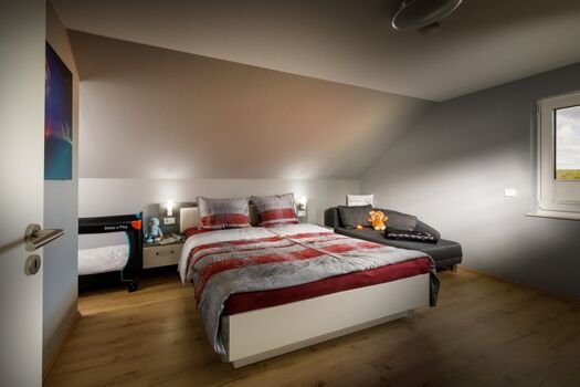 großes Schlafzimmer mit Liege und Kinderbett
