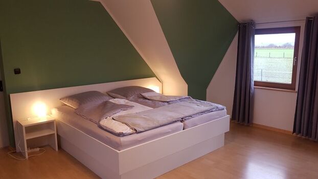 Schlafzimmer Eins mit Doppelbett und TV