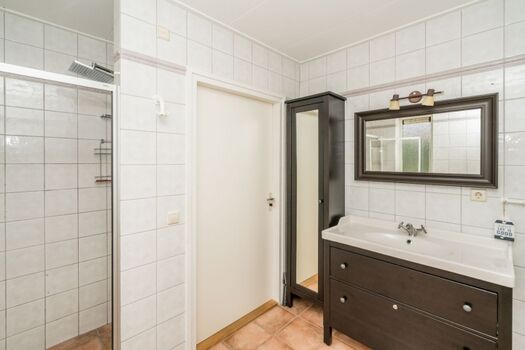 Das Badezimmer mit Dusche, Badmöbel und Toilette