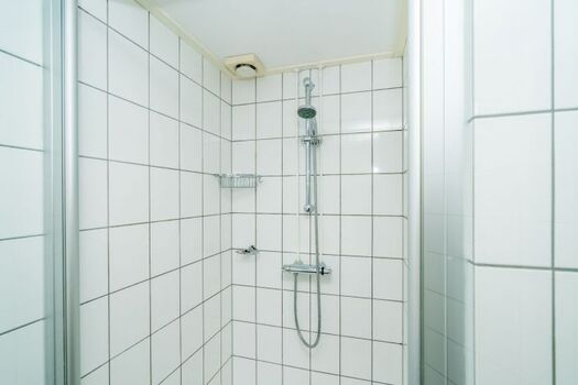 Das Bad mit Dusche und einem doppelten Waschbecken