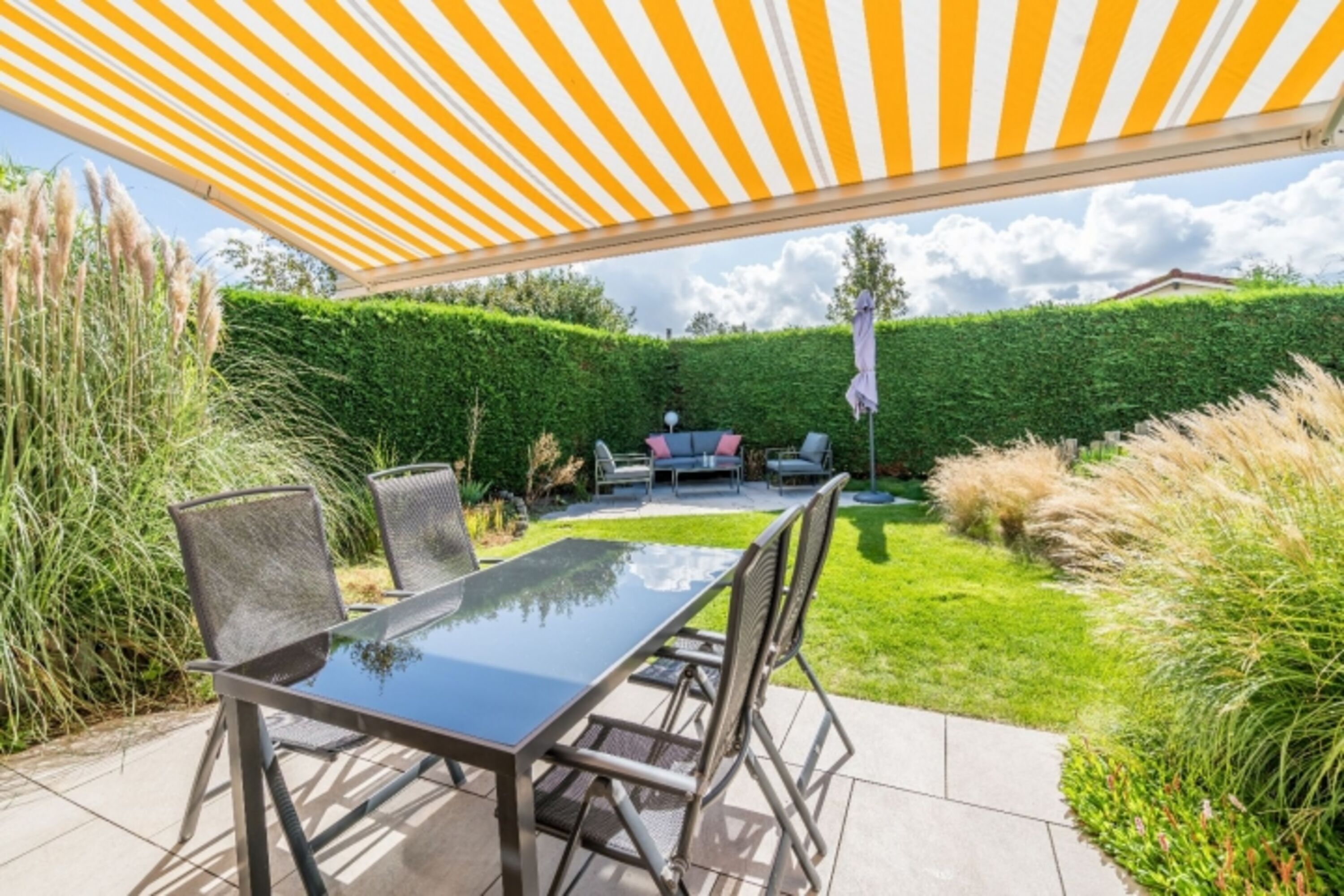 Die sonnige Terrasse mit Gartengruppe und elektrischer Markise