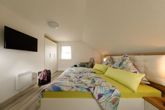 Großes Schlafzimmer mit TV und Schrank