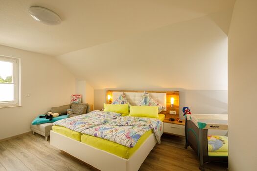 Eines von 2 großen Schlafzimmern mit Liege und Kinderbett