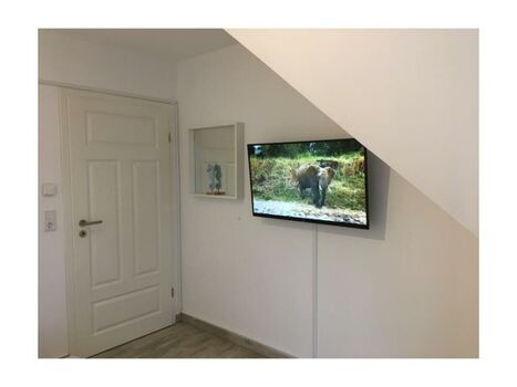 Schlafzimmer 1 mit wandhängendem TV.