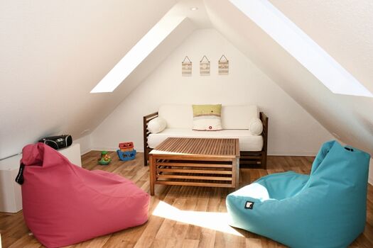 Gemütlich eingerichteter Spitzboden mit vielen Spielsachen und Büchern für Kinder