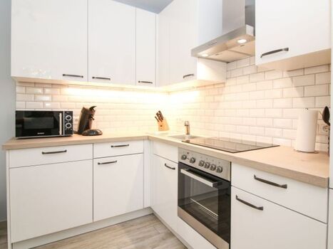 Voll ausgestattete Küche mit einem Bistro-Esstisch.