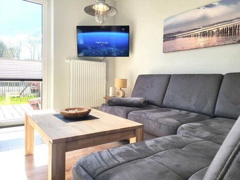 gemütliche Sofaecke mit TV und Blick in den Garten