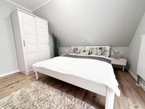 3. Schlafzimmer mit Doppelbett, Kleiderschrank, TV, Ganzkörperspiegel und bodentiefem Fenster