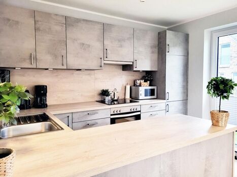 offene, komplett ausgestattete Küche mit zusätzlichem Zugang in den Garten