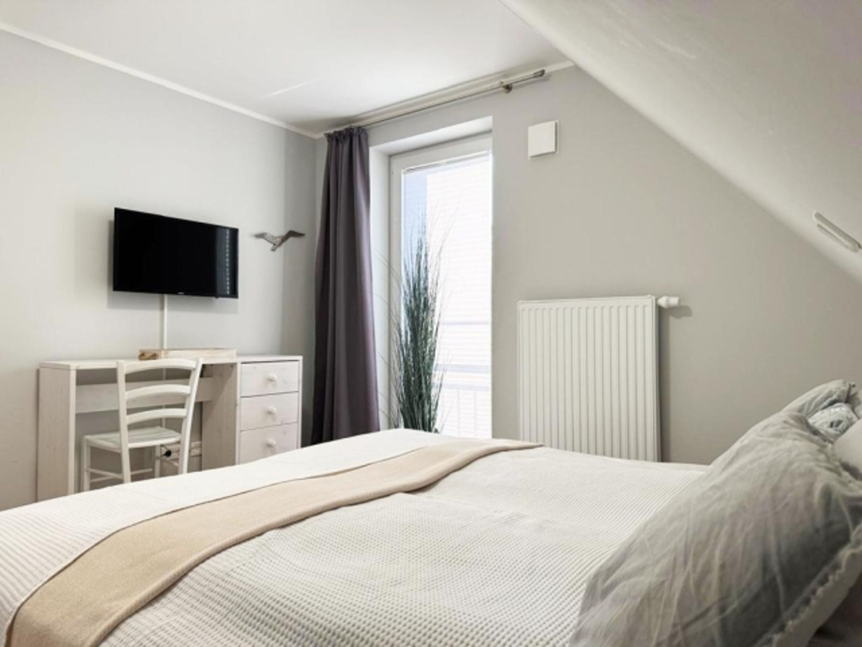 1. Schlafzimmer mit Doppelbett, Kleiderschrank, TV, Ganzkörperspiegel und bodentiefem Fenster