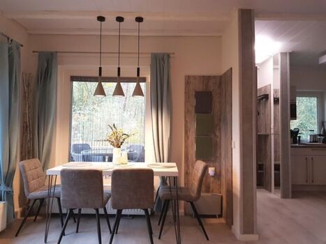 Essbereich mit tief liegenden Fenstern und Aussicht in die Natur