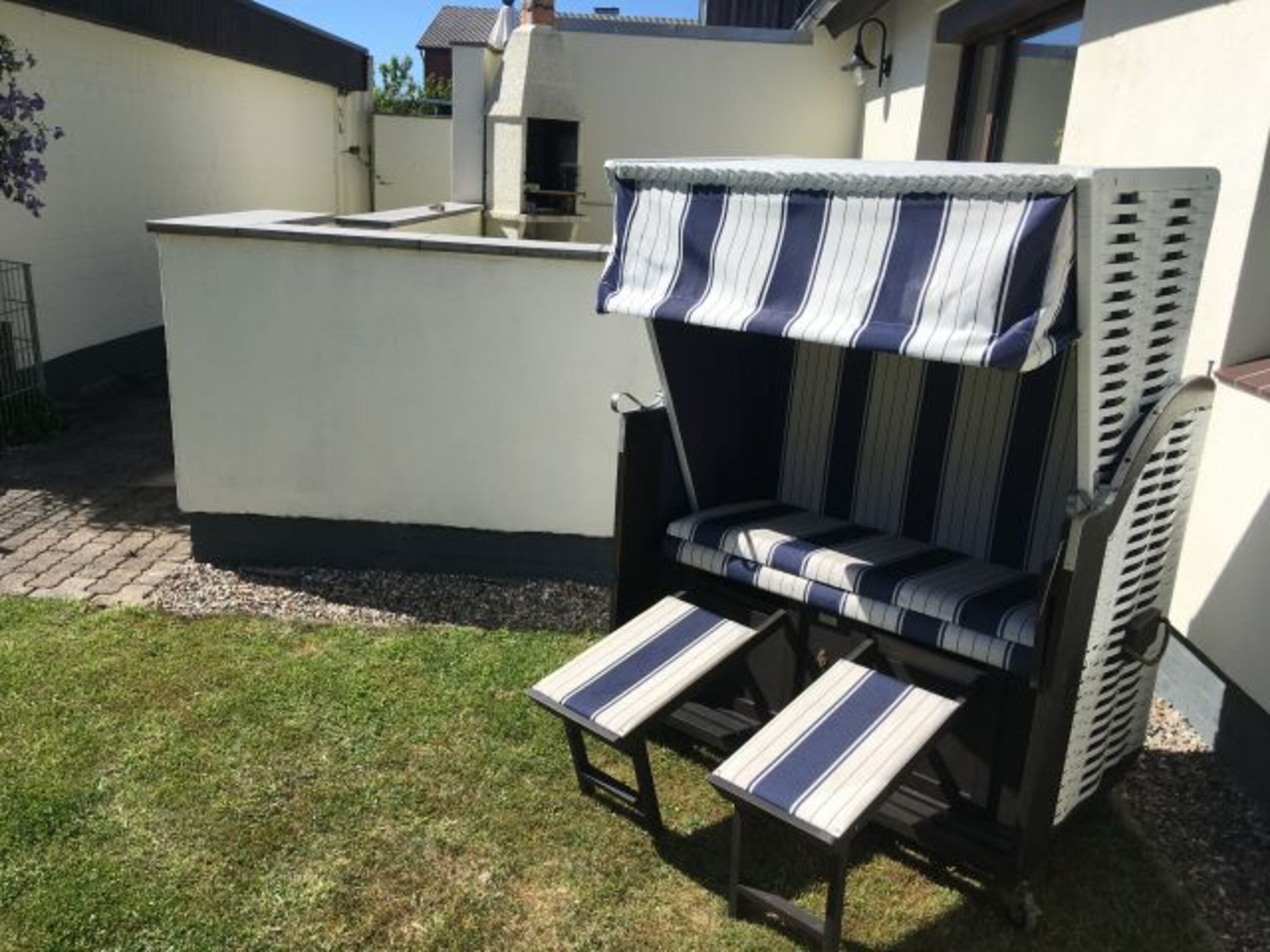 Strandkorb mit Blick auf Terrasse und den festen Grill