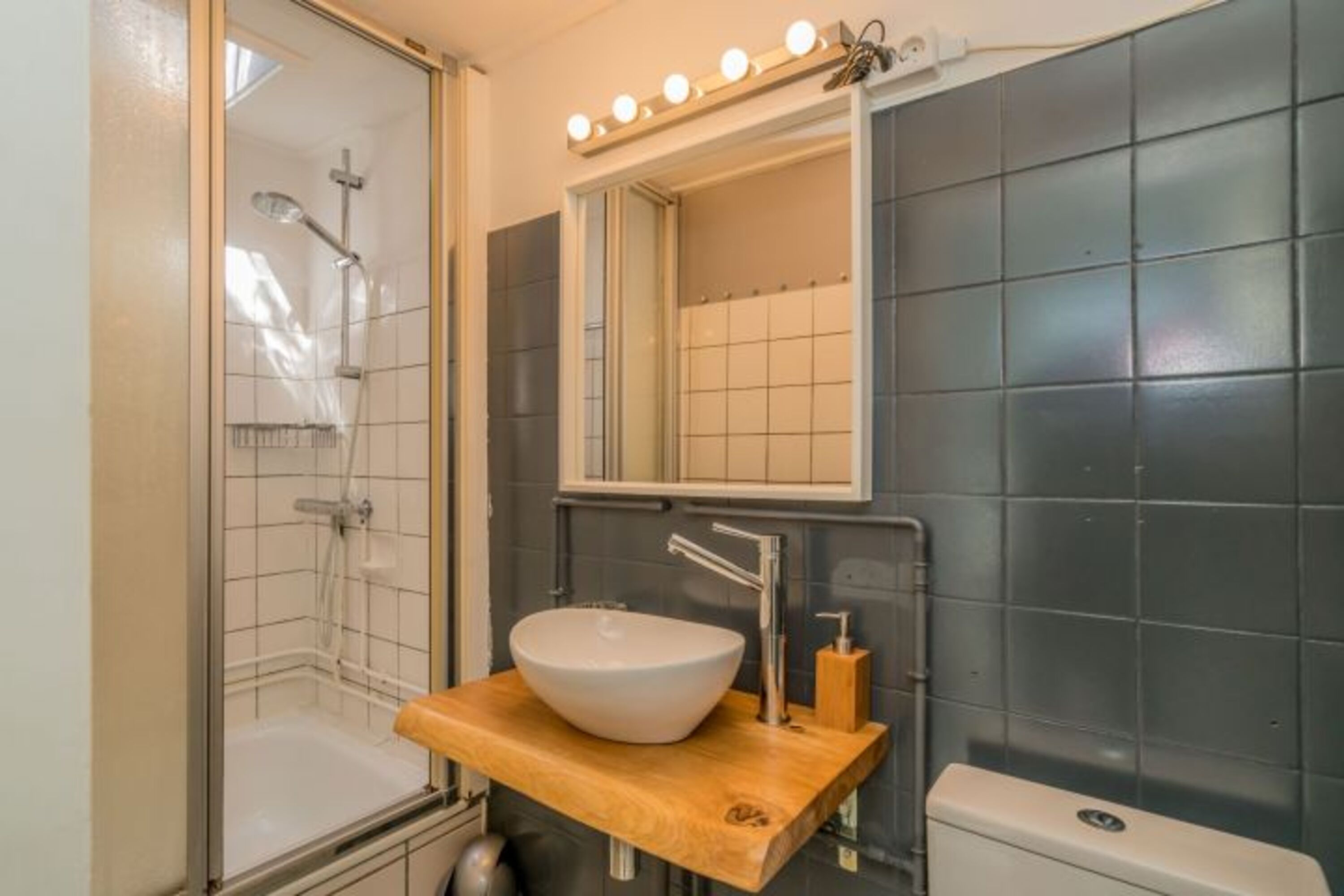 Badezimmer mit Dusche, Waschbecken und Toilette