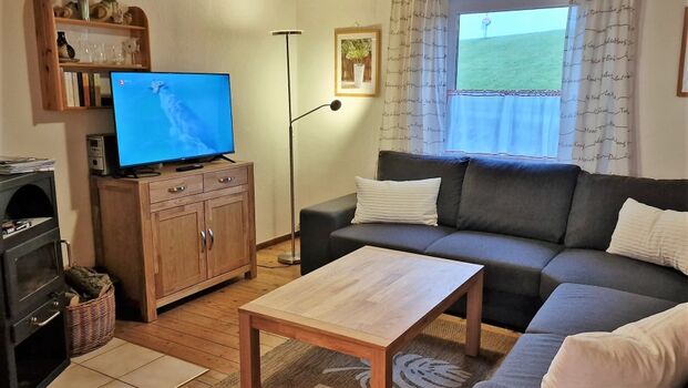 Das gemütliche Wohnzimmer mit Sitzecke und Kamin