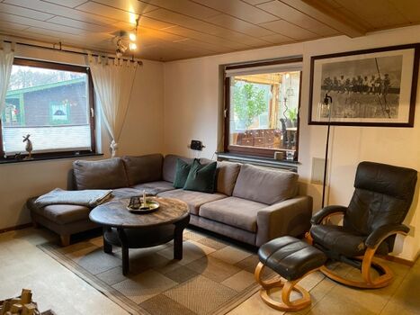 Wohnbereich mit großem Sofa und gemütlichen Sessel.