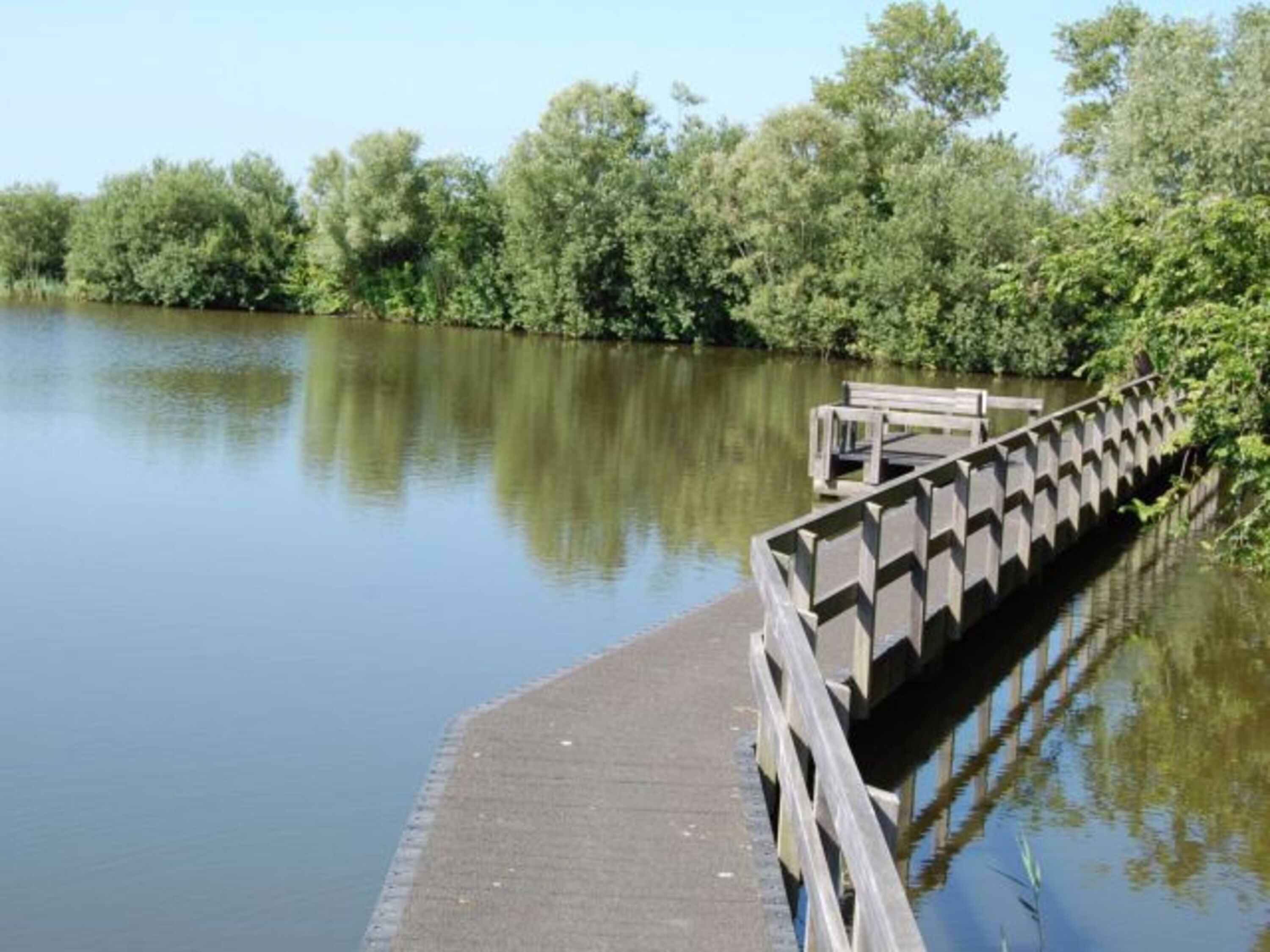 See mit Holzbrücke vor der Terrasse