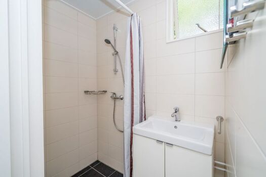 Badezimmer mit Dusche und Waschbecken