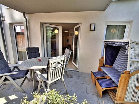 überdachte Terrasse mit Sitzmöglichkeiten und Strandkorb