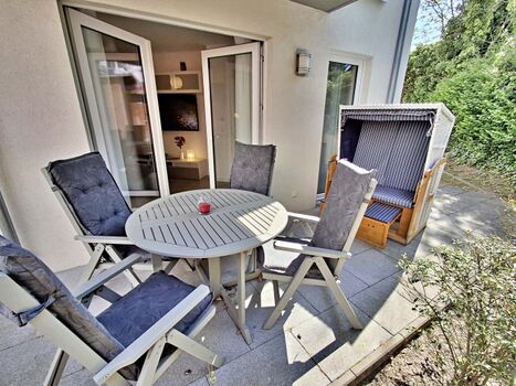 überdachte Terrasse mit Sitzmöglichkeiten und Strandkorb