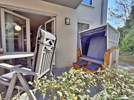 überdachte Terrasse mit Sitzmöglichkeiten und Strandkorb