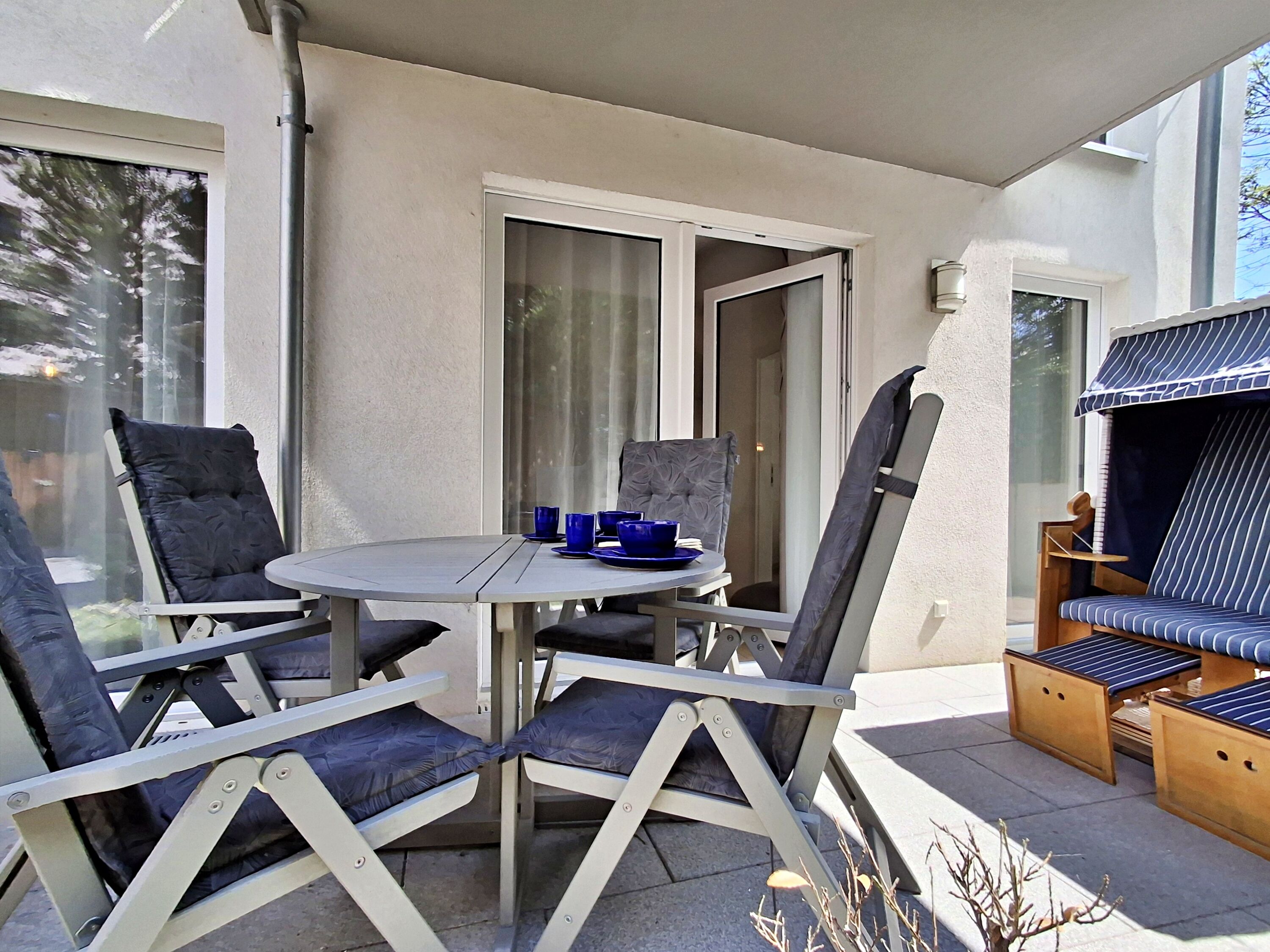 überdachte Terrasse mit Sitzmöglichkeiten und Strandkorb