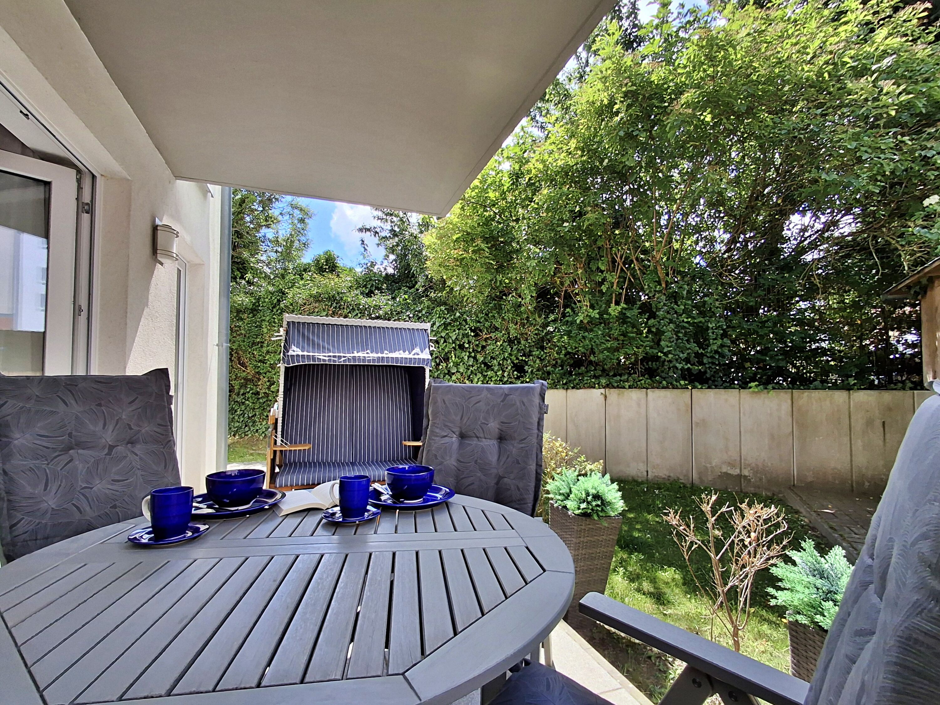 überdachte Terrasse mit Sitzmöglichkeiten und Strandkorb