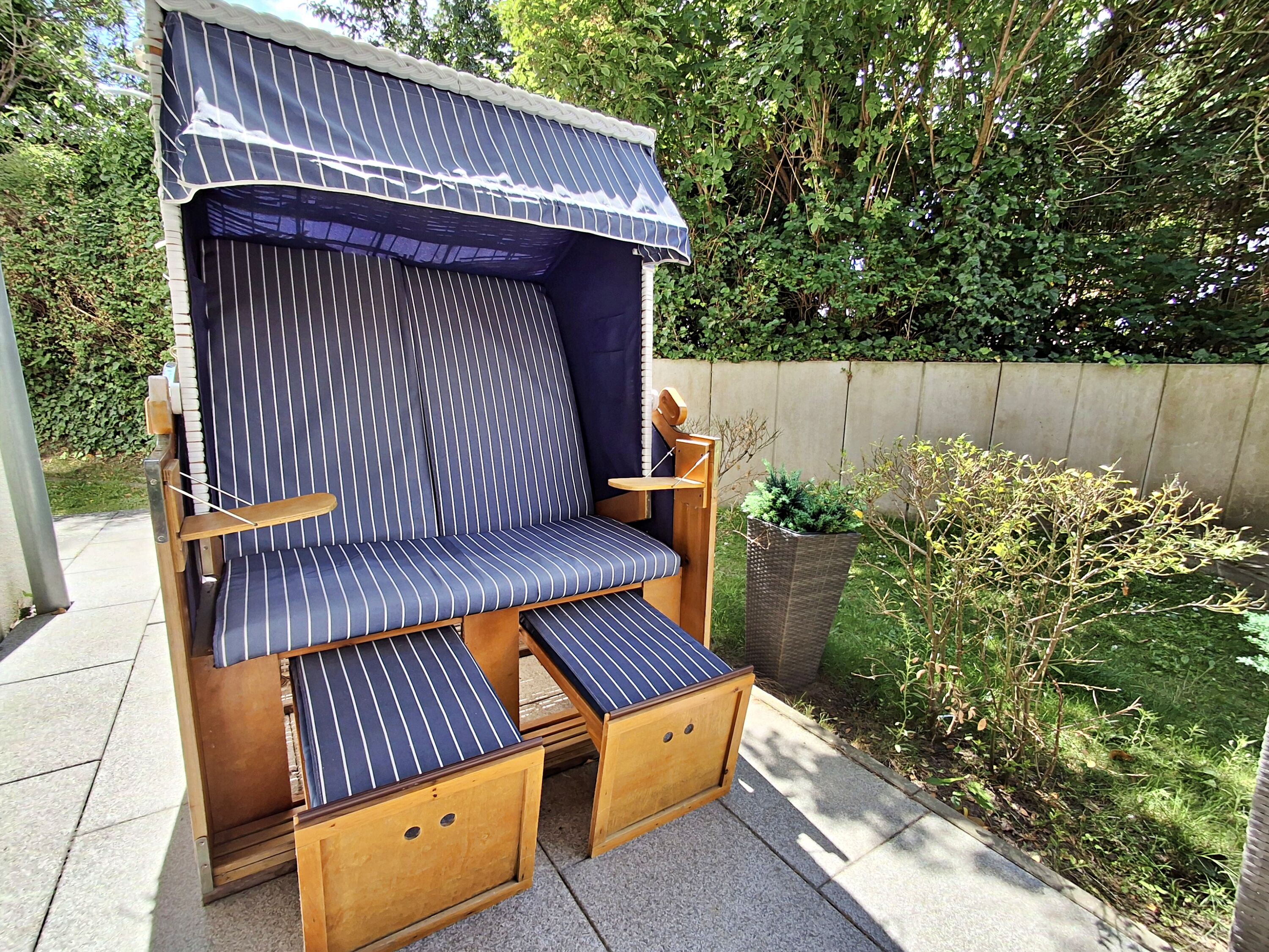 überdachte Terrasse mit Sitzmöglichkeiten und Strandkorb