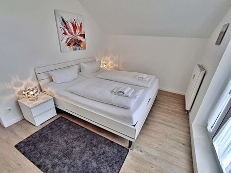 Schlafzimmer mit Doppelbett und zusätzlichem Flachbild-TV