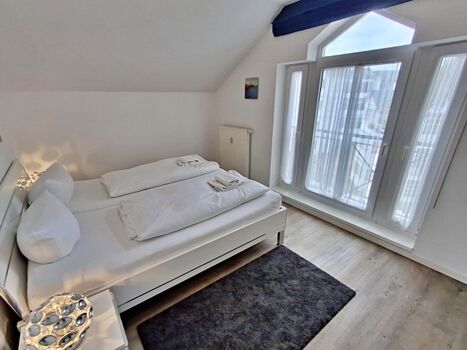 Schlafzimmer mit Doppelbett und zusätzlichem Flachbild-TV