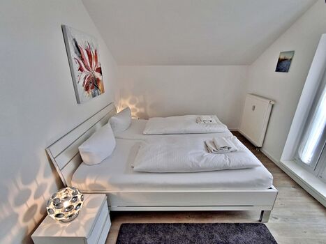 Schlafzimmer mit Doppelbett und zusätzlichem Flachbild-TV