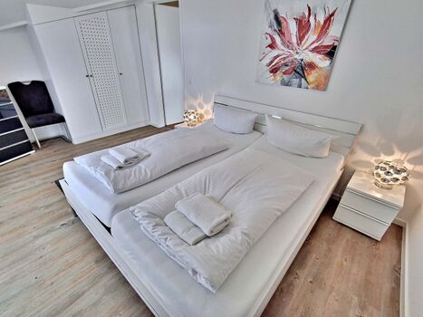 Schlafzimmer mit Doppelbett und zusätzlichem Flachbild-TV