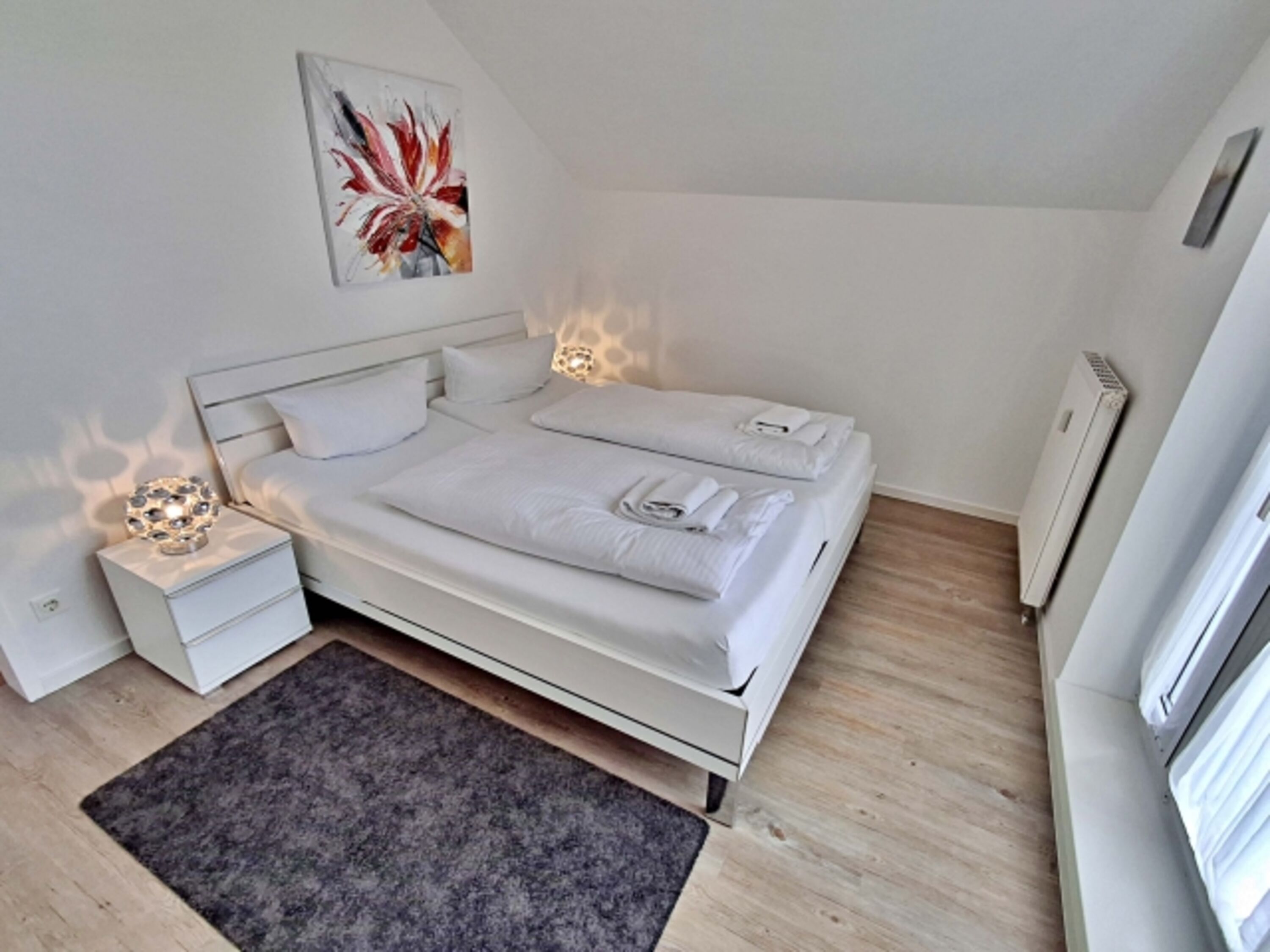 Schlafzimmer mit Doppelbett und zusätzlichem Flachbild-TV